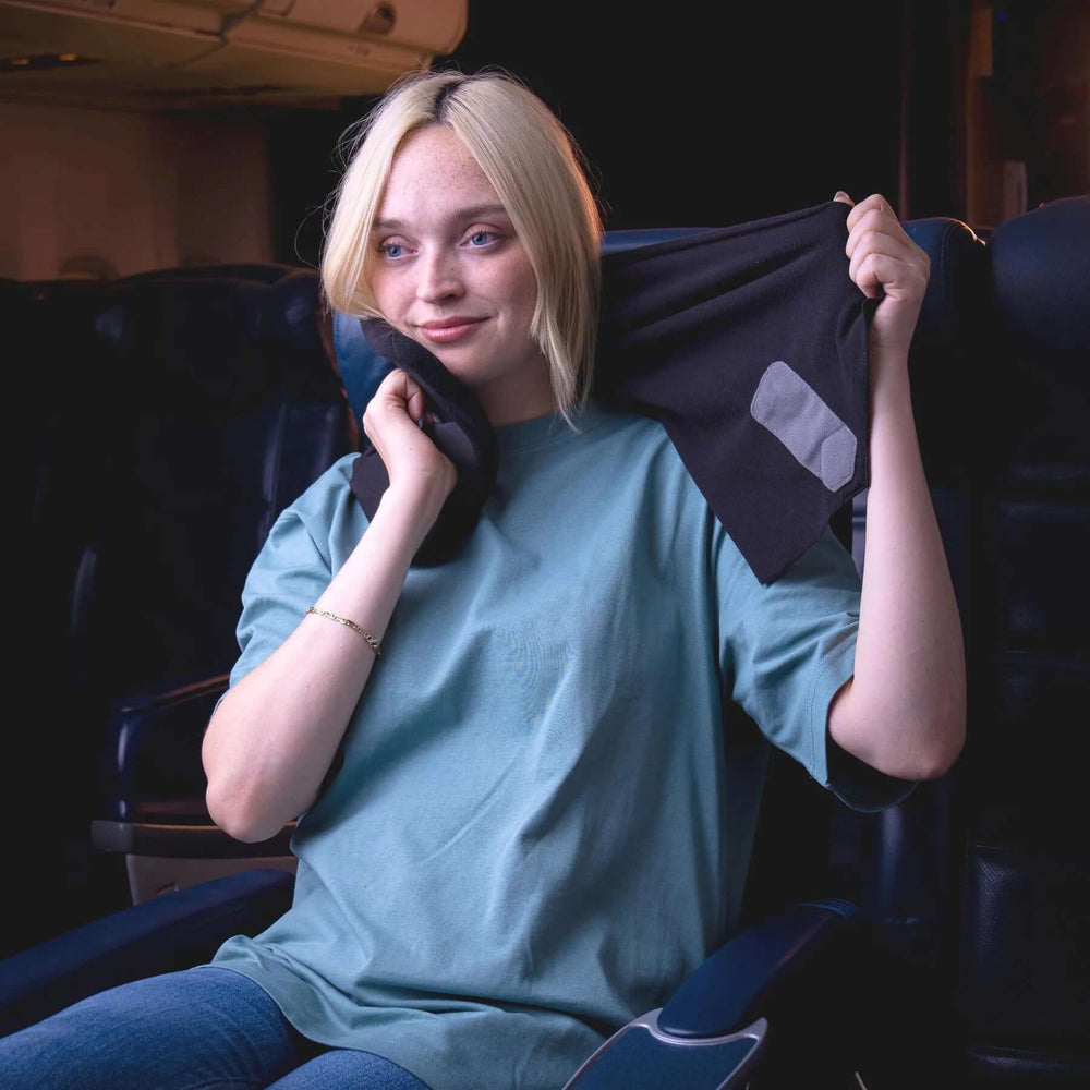 Person der bruger den ortopædiske nakkepude under en rejse