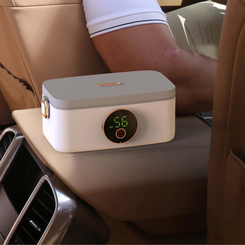 Elektrisk madkasse i sort og hvid med mad i rustfri stålbeholder