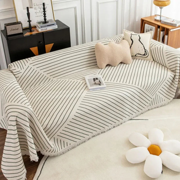 Elegant skandinavisk sofabetræk med kvaster i forskellige størrelser og farver.