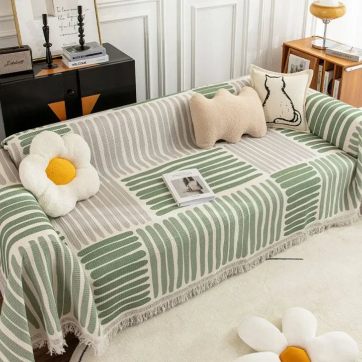 Elegant skandinavisk sofabetræk med kvaster i forskellige størrelser og farver.