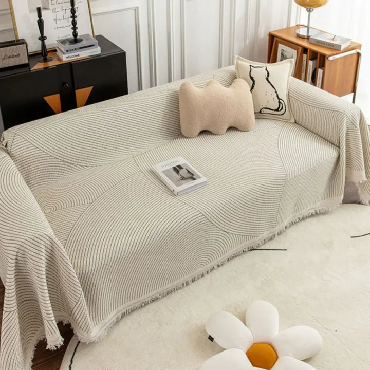 Elegant skandinavisk sofabetræk med kvaster i forskellige størrelser og farver.