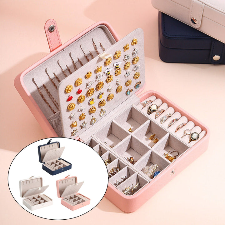 Elegant smykkeskrin i læder med klaplåg, kompakt i blå, rosa, hvid, til stilfuld opbevaring af ringe og øreringe.