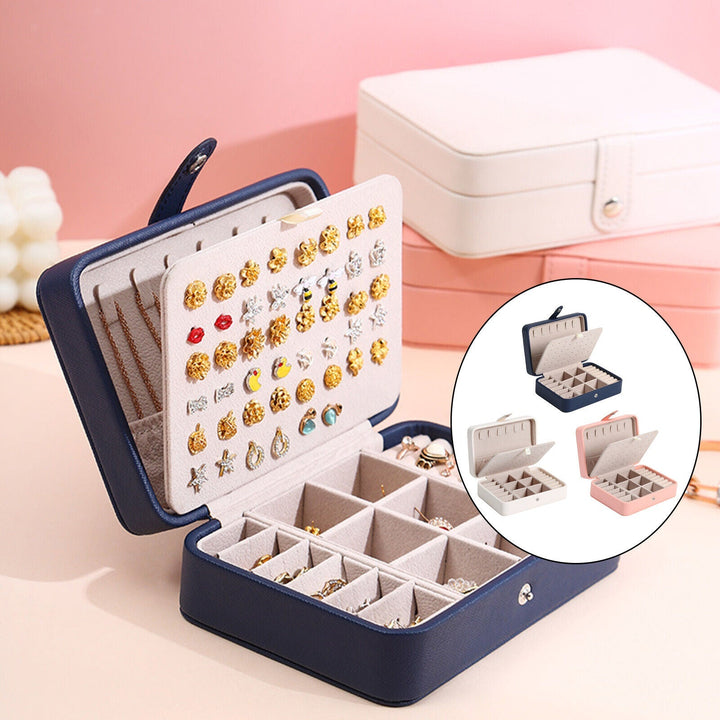 Elegant smykkeskrin i læder med klaplåg, kompakt i blå, rosa, hvid, til stilfuld opbevaring af ringe og øreringe.