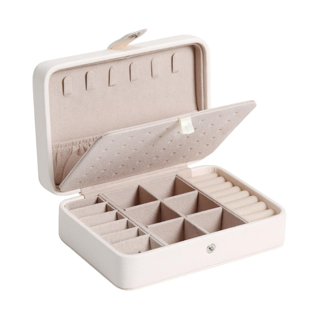 Elegant smykkeskrin i læder med klaplåg, kompakt i blå, rosa, hvid, til stilfuld opbevaring af ringe og øreringe.