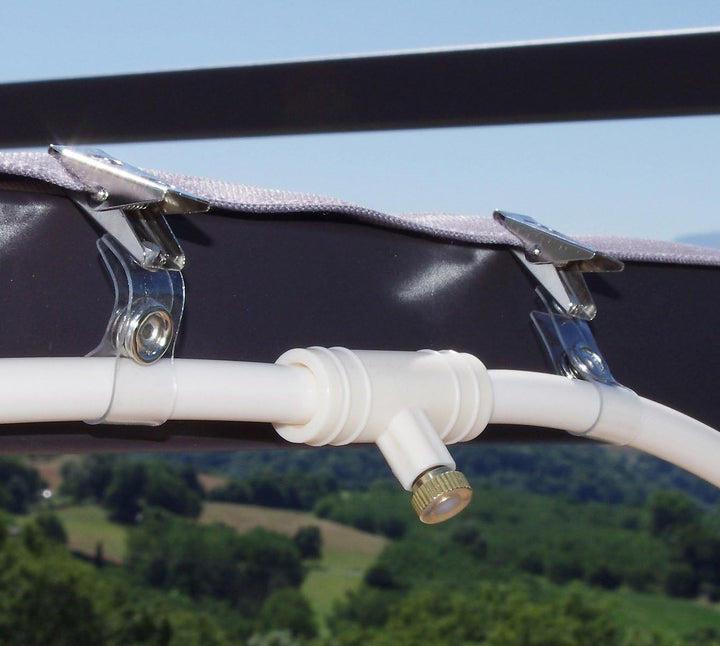 Fleksibelt sprøjtevandingssystem, grøn slange med jævne sprøjtedyser, ideel til haveforfriskning på sommerdage.