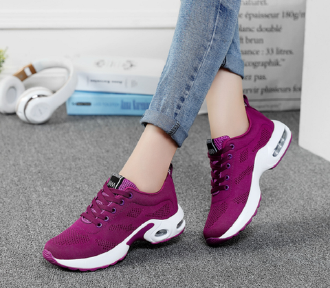 Ortopædiske løbesko til kvinder i lyseblå-lilla, set fra siden, med detaljer om ergonomisk design.