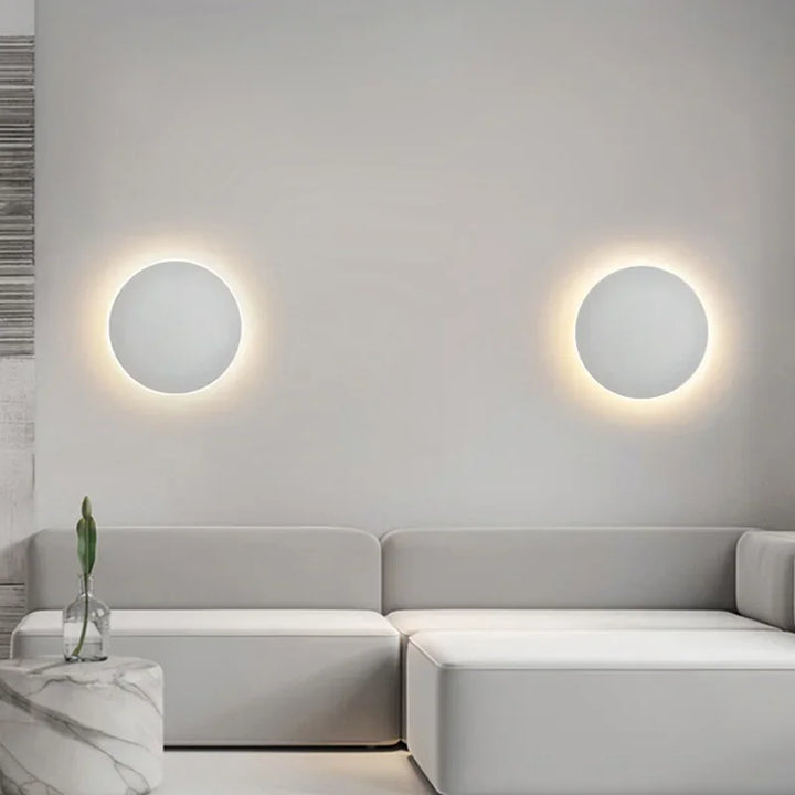 Rund, moderne LED-væglampe med elegant, minimalistisk design, ideel til stilfuld indendørsbelysning.