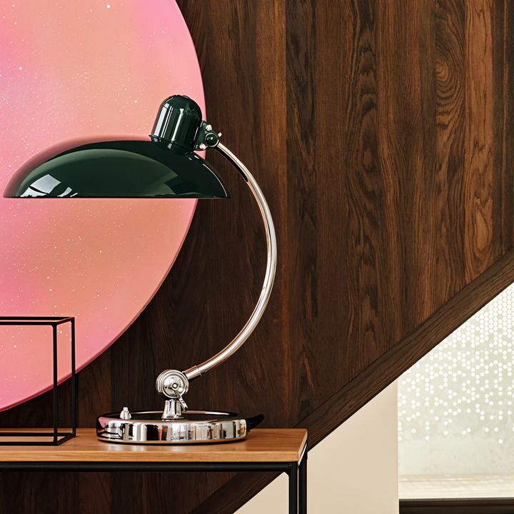 Justerbar bordlampe i jern med retrodesign og industriel stil, giver varmt lys til skrivebord eller læsehjørne.