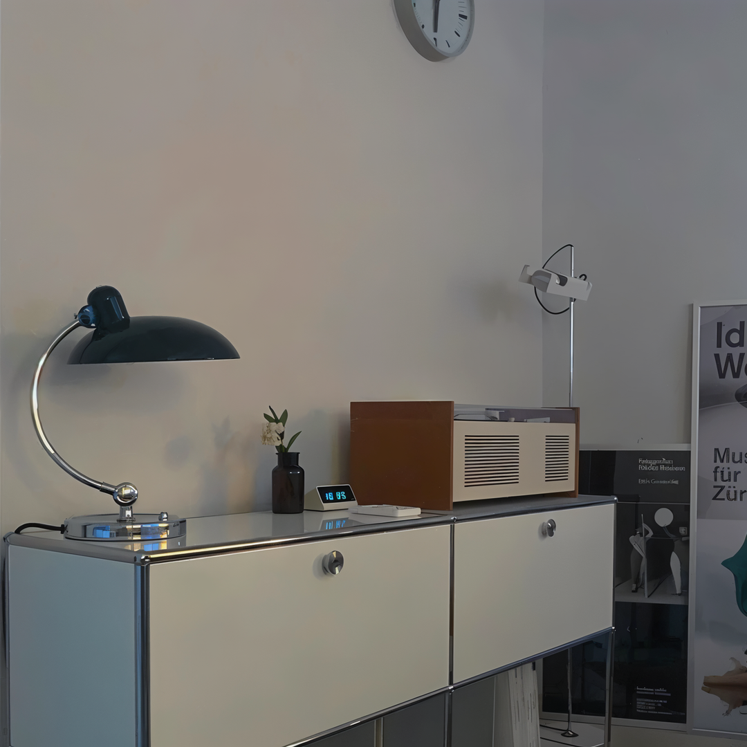Justerbar bordlampe i jern med retrodesign og industriel stil, giver varmt lys til skrivebord eller læsehjørne.