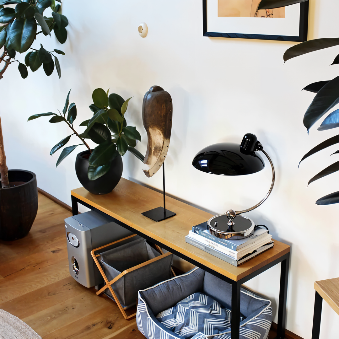 Justerbar bordlampe i jern med retrodesign og industriel stil, giver varmt lys til skrivebord eller læsehjørne.