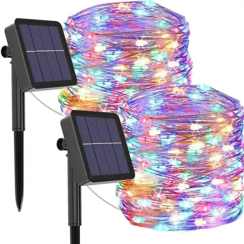 Vandafvisende solcelledrevet lyskæde i haven ved daggry, varme LED-lys, stemningsfuld udendørs belysning