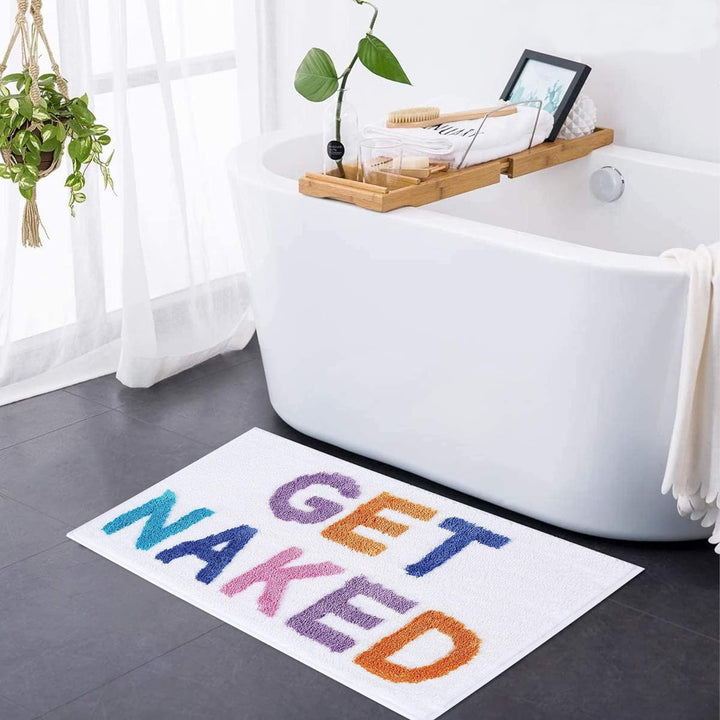 Blød tuftet bademåtte med "Get Naked" tekst i moderne design for et stilfuldt og komfortabelt badeværelse.