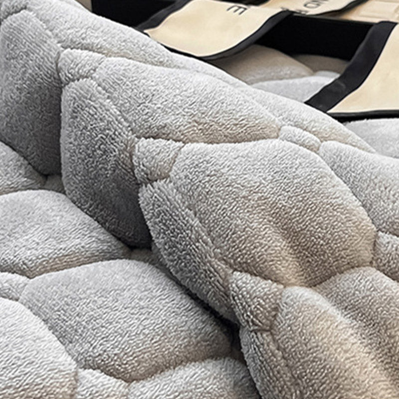 Blødt dagsengetæppe med kvadratisk tekstur, fluffy og moderne, draperet på sofaen for stilfuld hygge.
